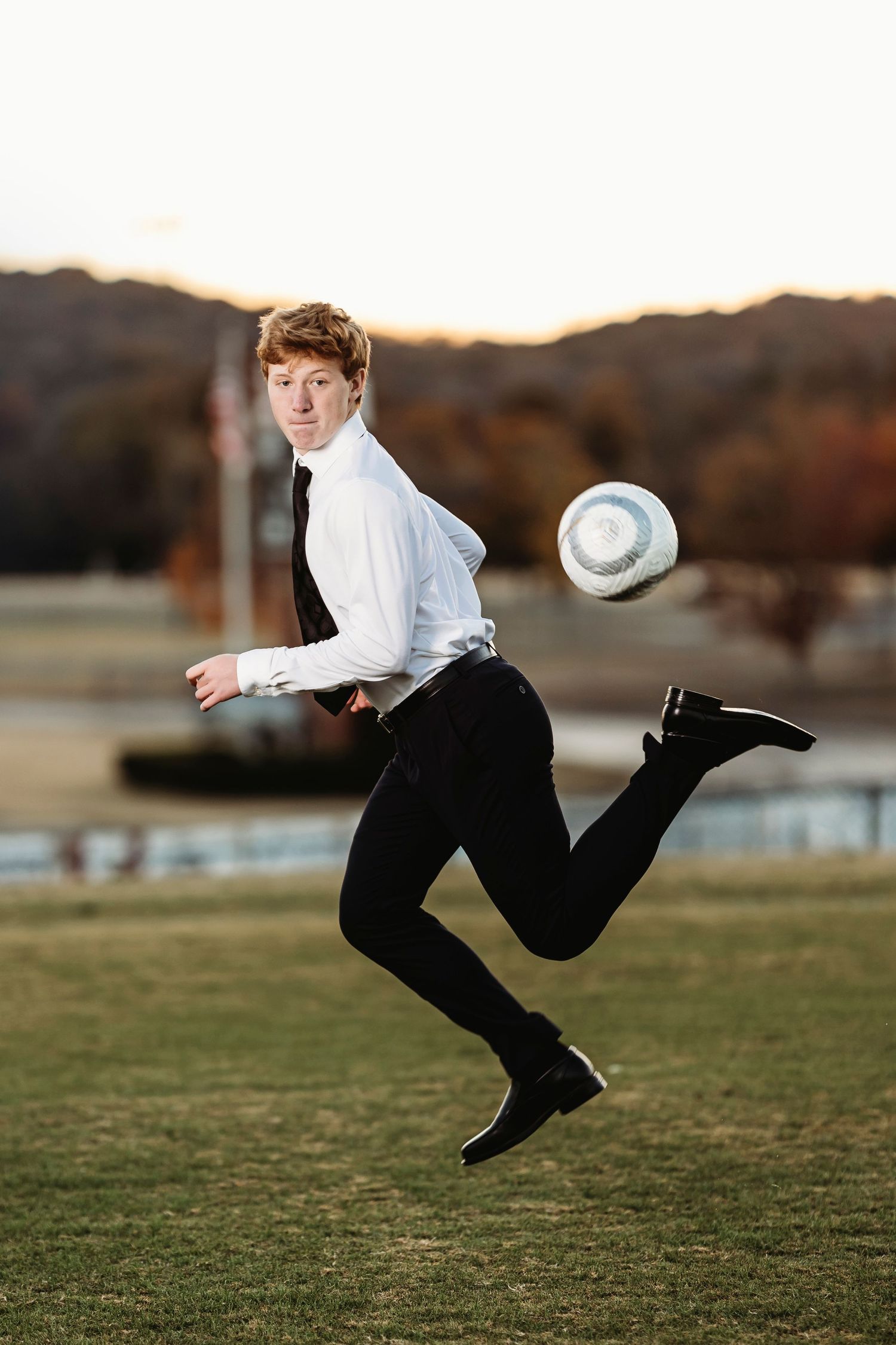 Soccer player performing an acrobatic kick on a grassy field during sunset.  Middle TN senior photographer