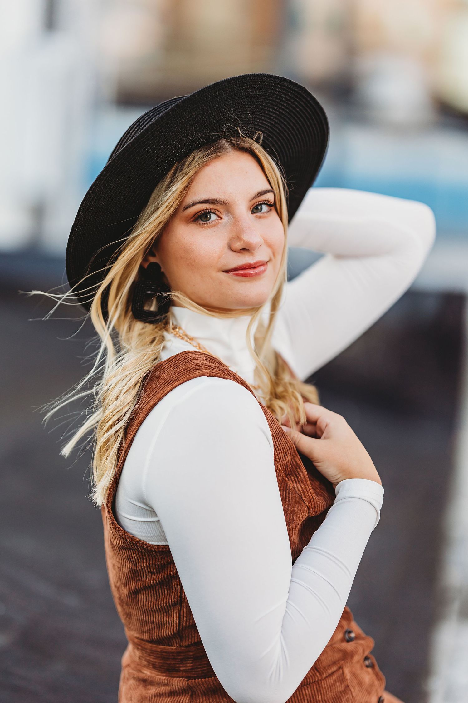 Fashion portrait series featuring a wide-brimmed black hat and brown vest against neutral background. Middle TN senior photographer
