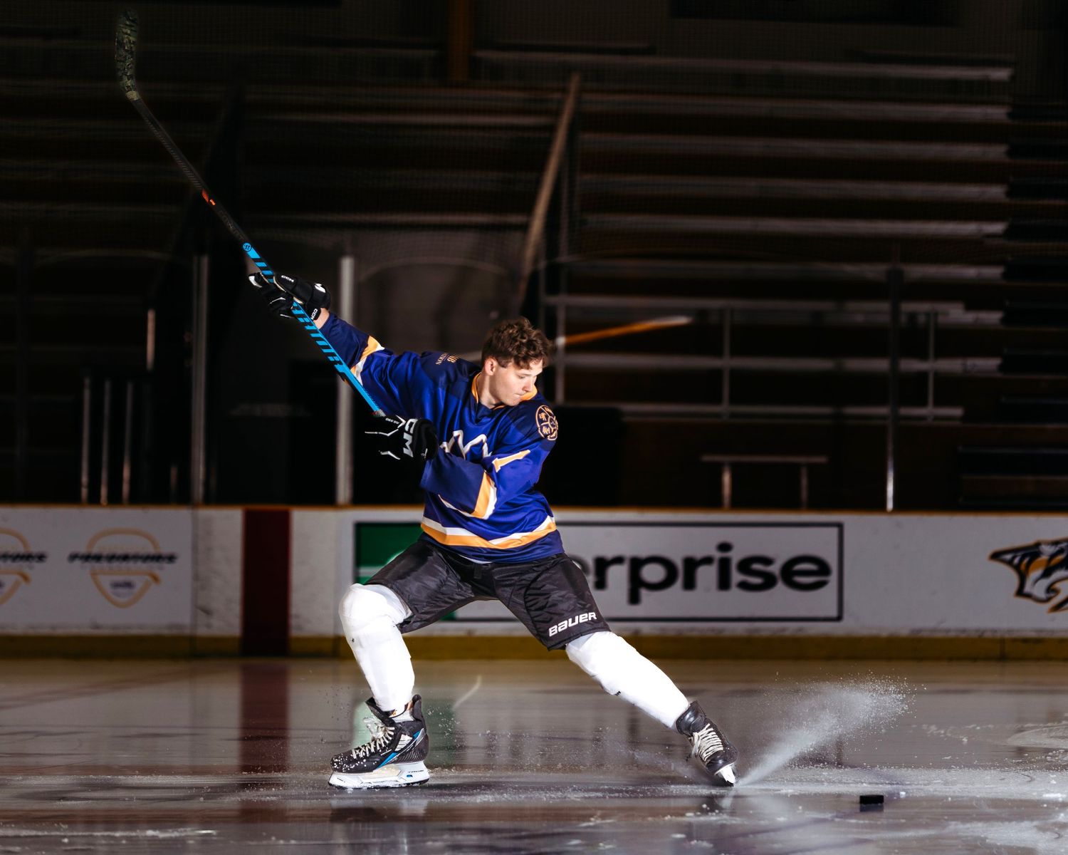 Ice skater performing dynamic jumps and spins on indoor rink during performance. Middle TN senior photographer