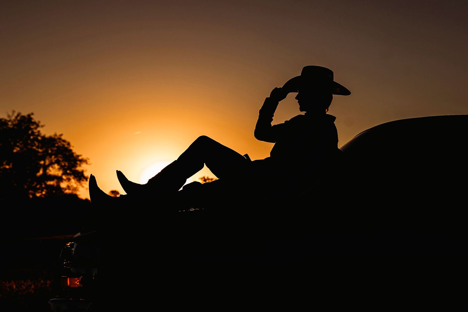Silhouettes of senior guy against an orange sunset sky.Middle TN senior photographer