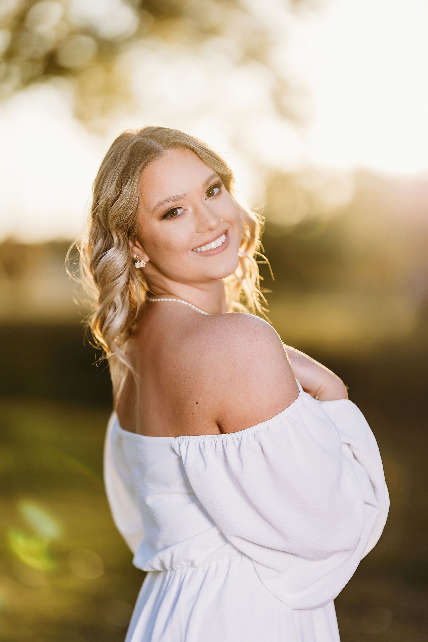 Ethereal outdoor portrait series with white off-shoulder top in golden sunlight. Middle TN senior photographer