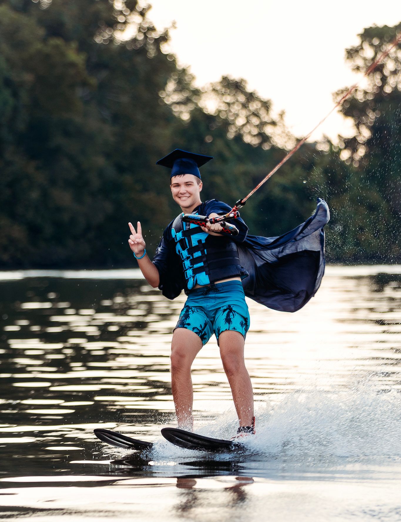 Sequence showing senior guy in graduation attire performing water sports tricks on a lake. Middle TN senior photographer