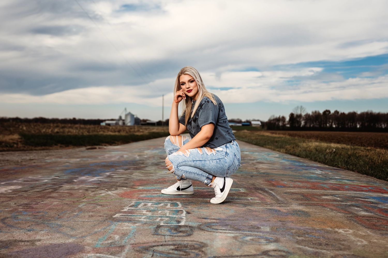 Person lounging on painted concrete surface under cloudy sky. Middle TN senior photographer