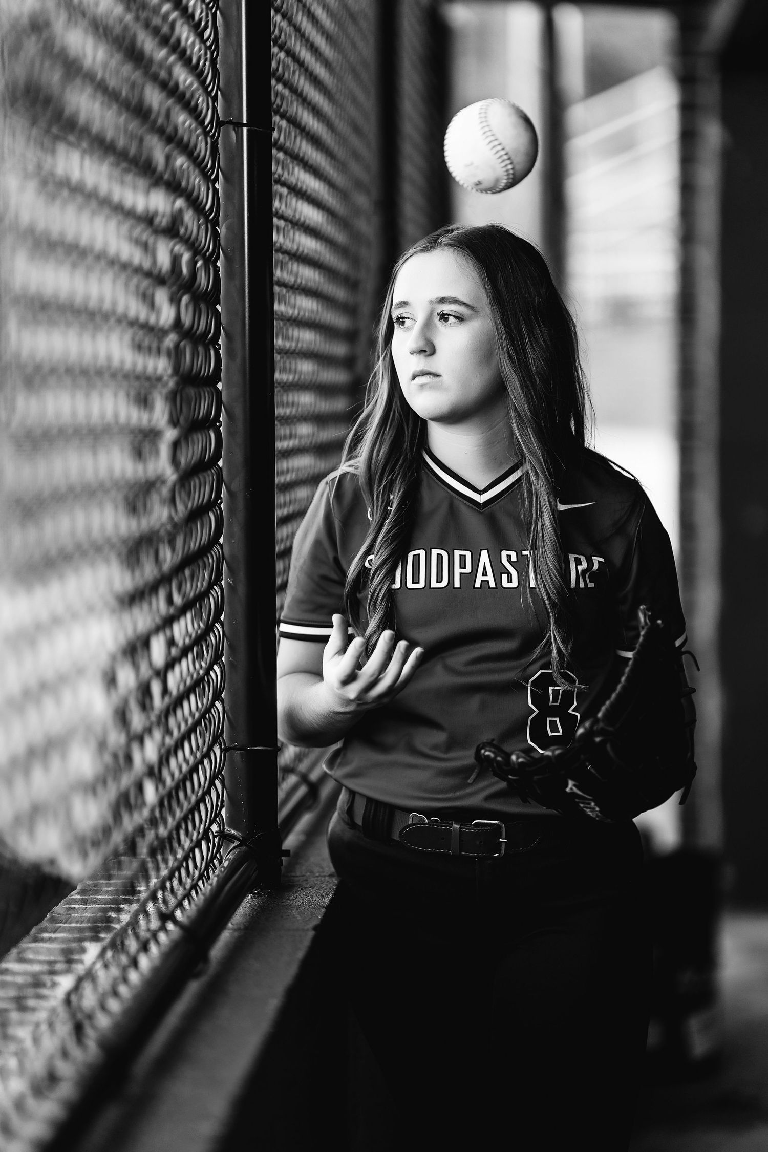 Black and white softball portraits showing player in batting stance against fence. Middle TN senior photographer