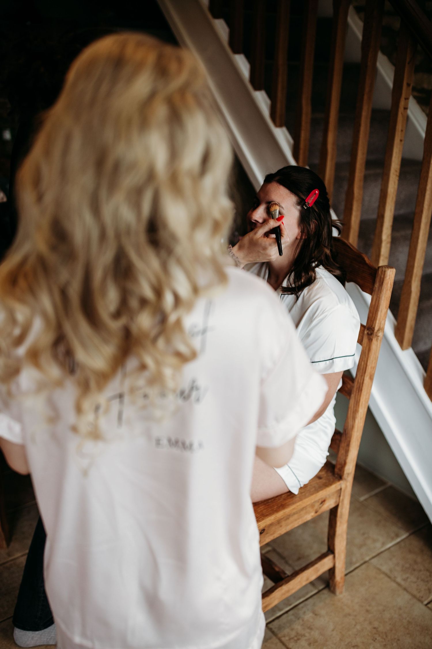 A behind-the-scenes shot of wedding day makeup preparations on wooden stairs.