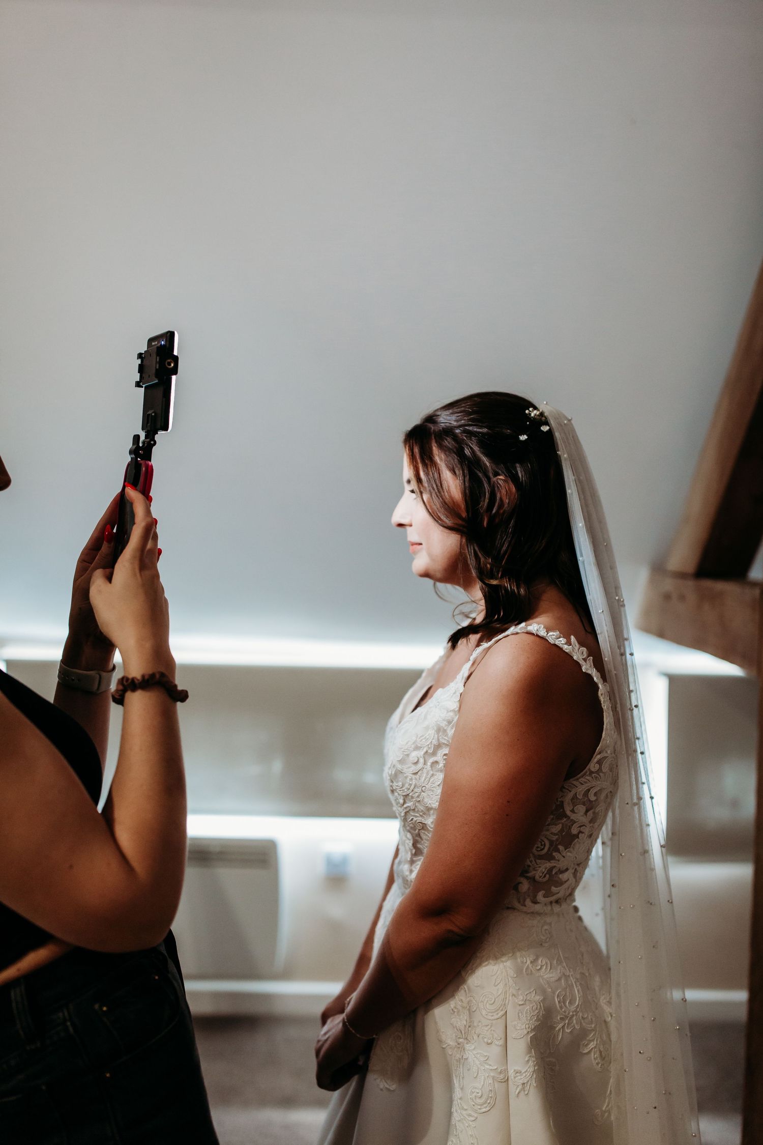 Side profile of person in wedding attire being photographed in natural light.