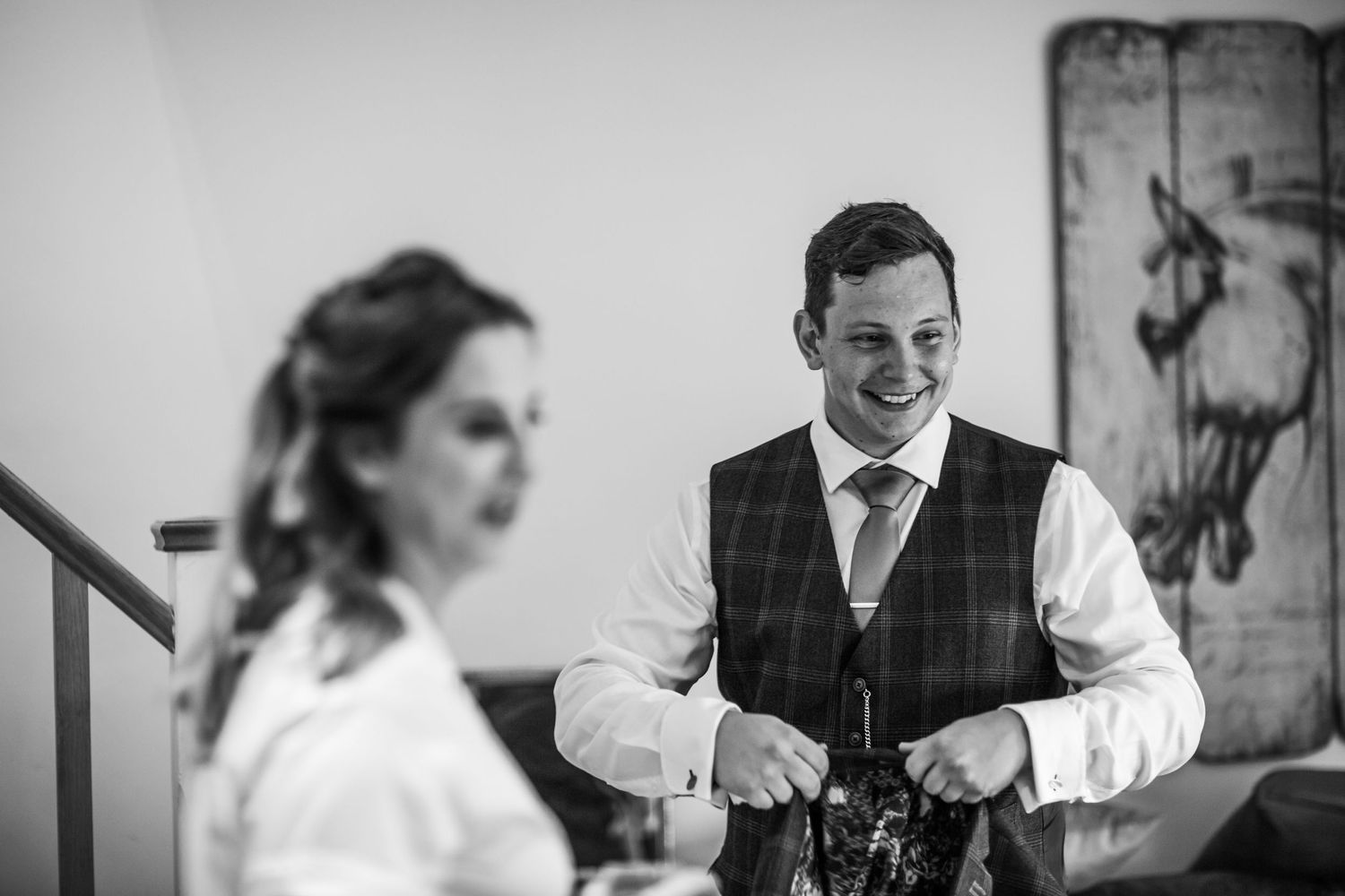 Person in formal attire preparing during a wedding celebration.