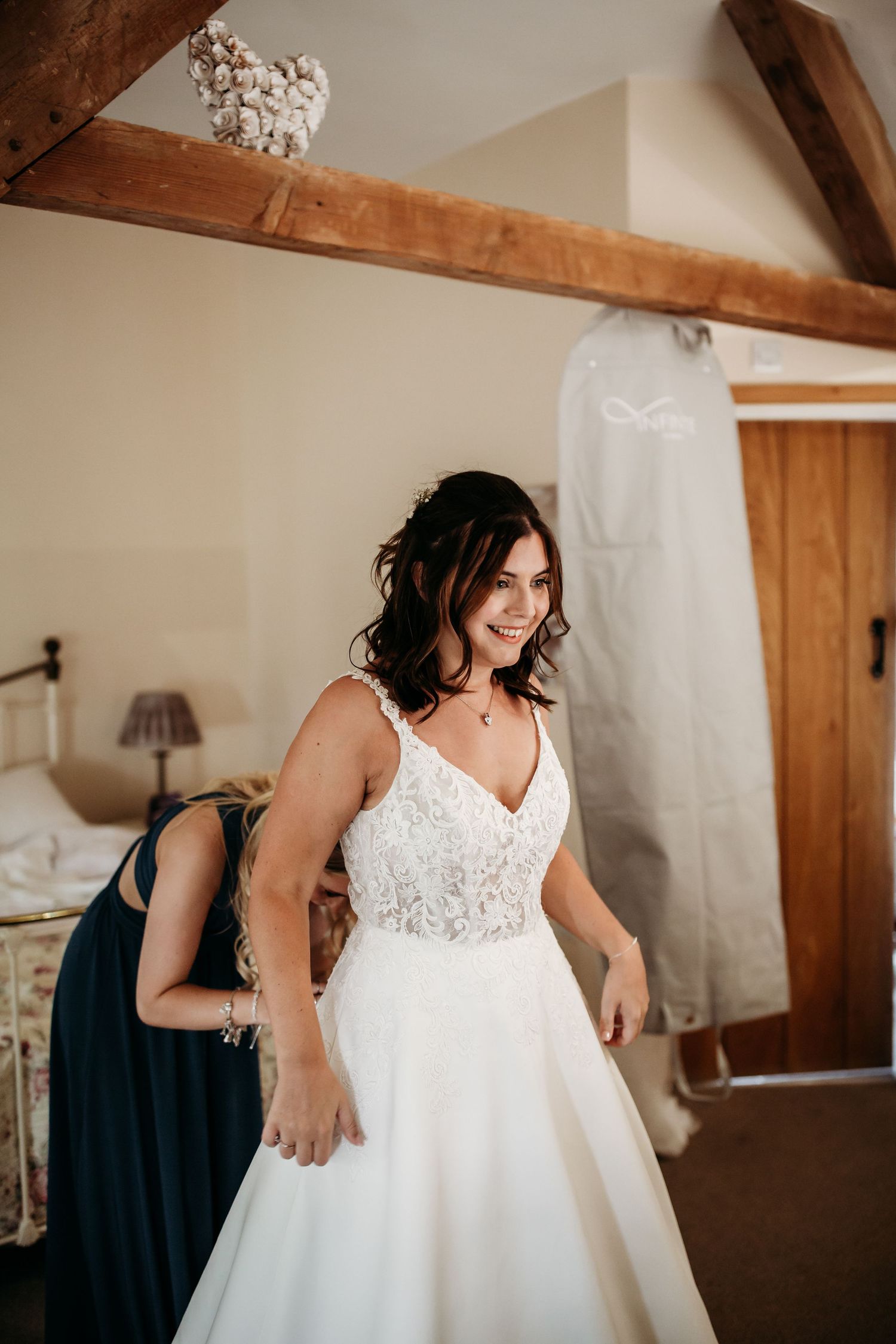 Joyful moment during wedding preparations in rustic room with exposed beams.