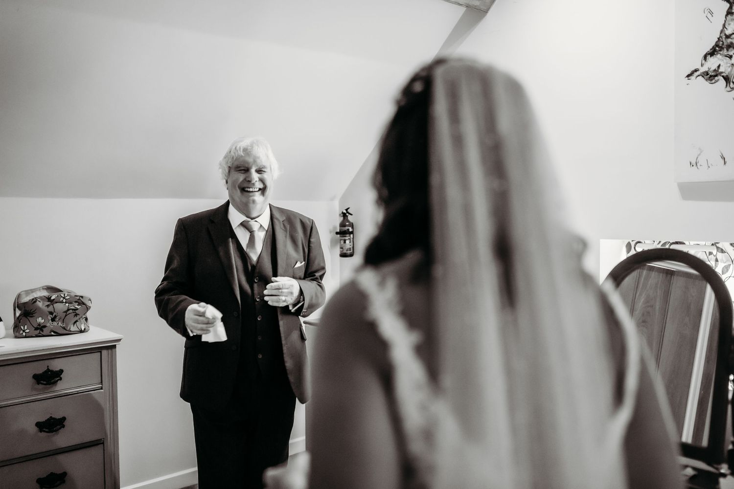 Black and white emotional first look moment as proud father sees bride in wedding dress.