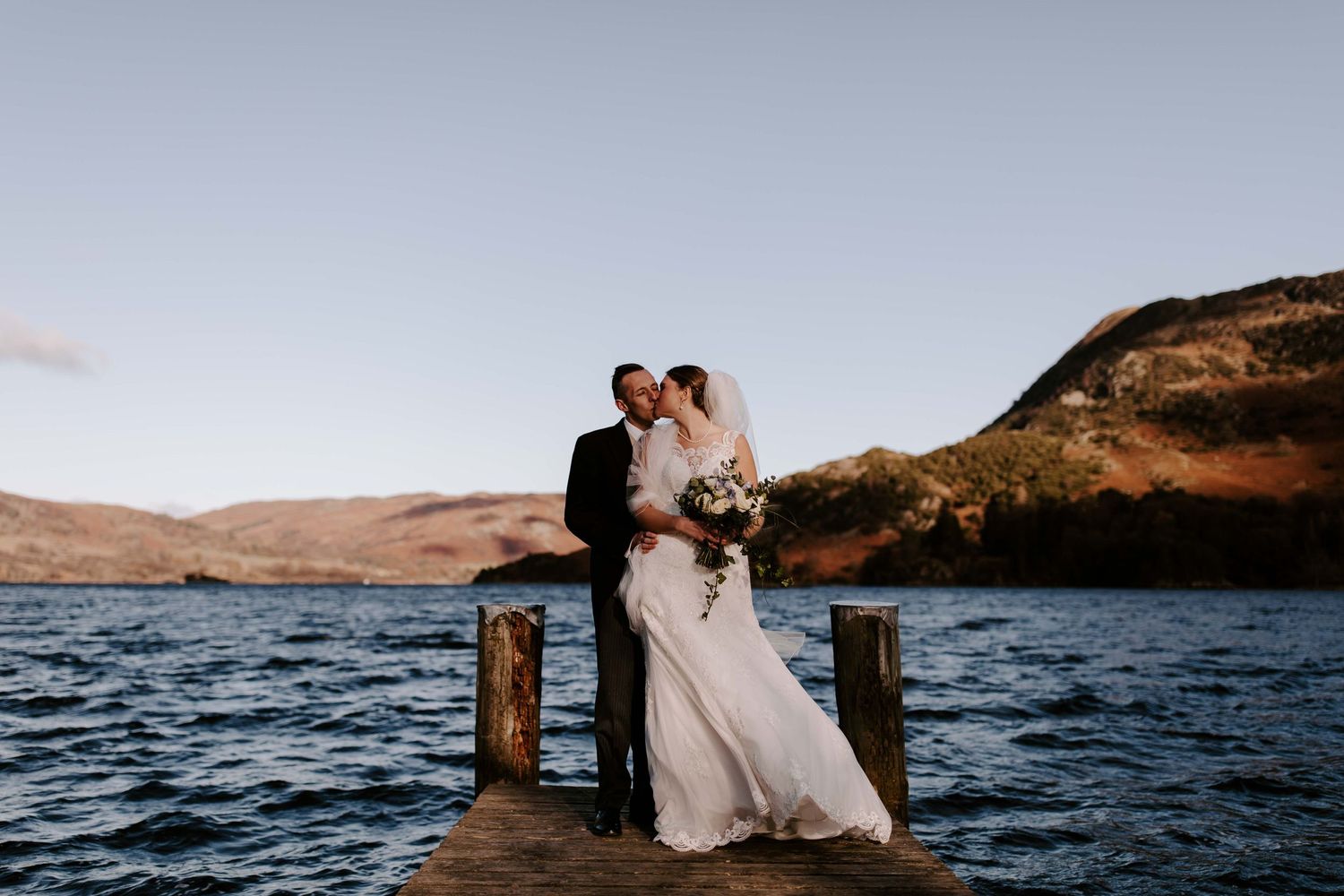 Ullswater In Cumbria, the Lake District, portrait if couple on the jetty on wedding day