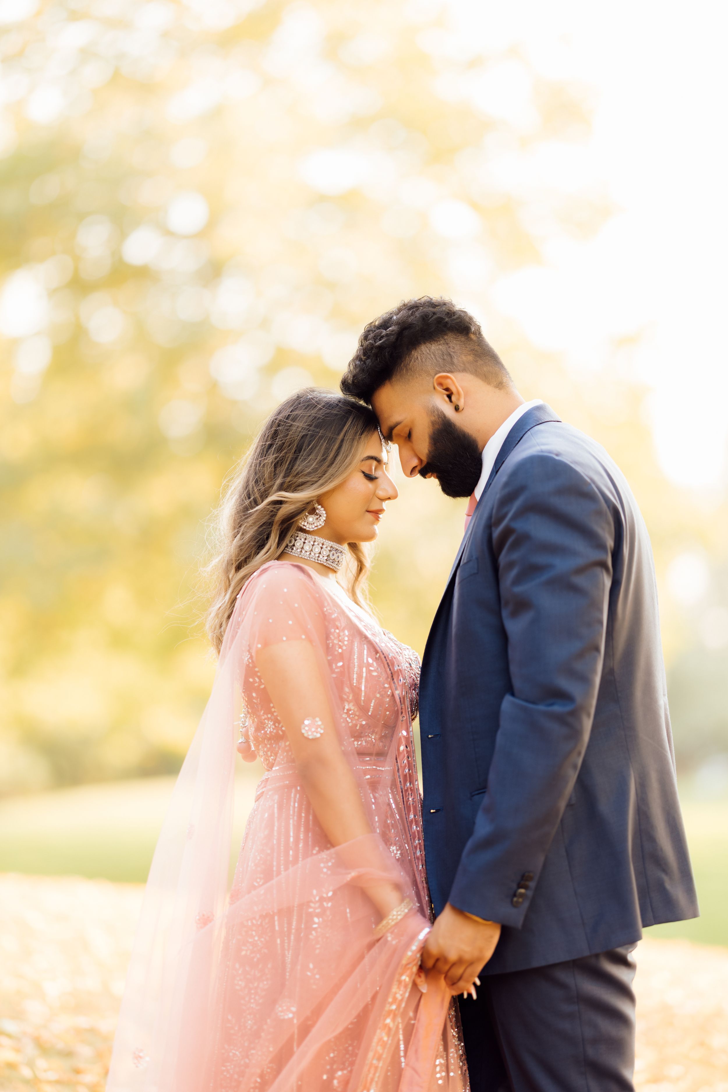 Tender moment between couple in formal wear during autumn photoshoot.
