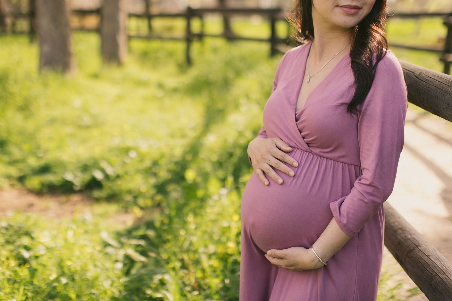 Series of maternity portraits showing a woman in a mauve dress standing near a rustic fence.