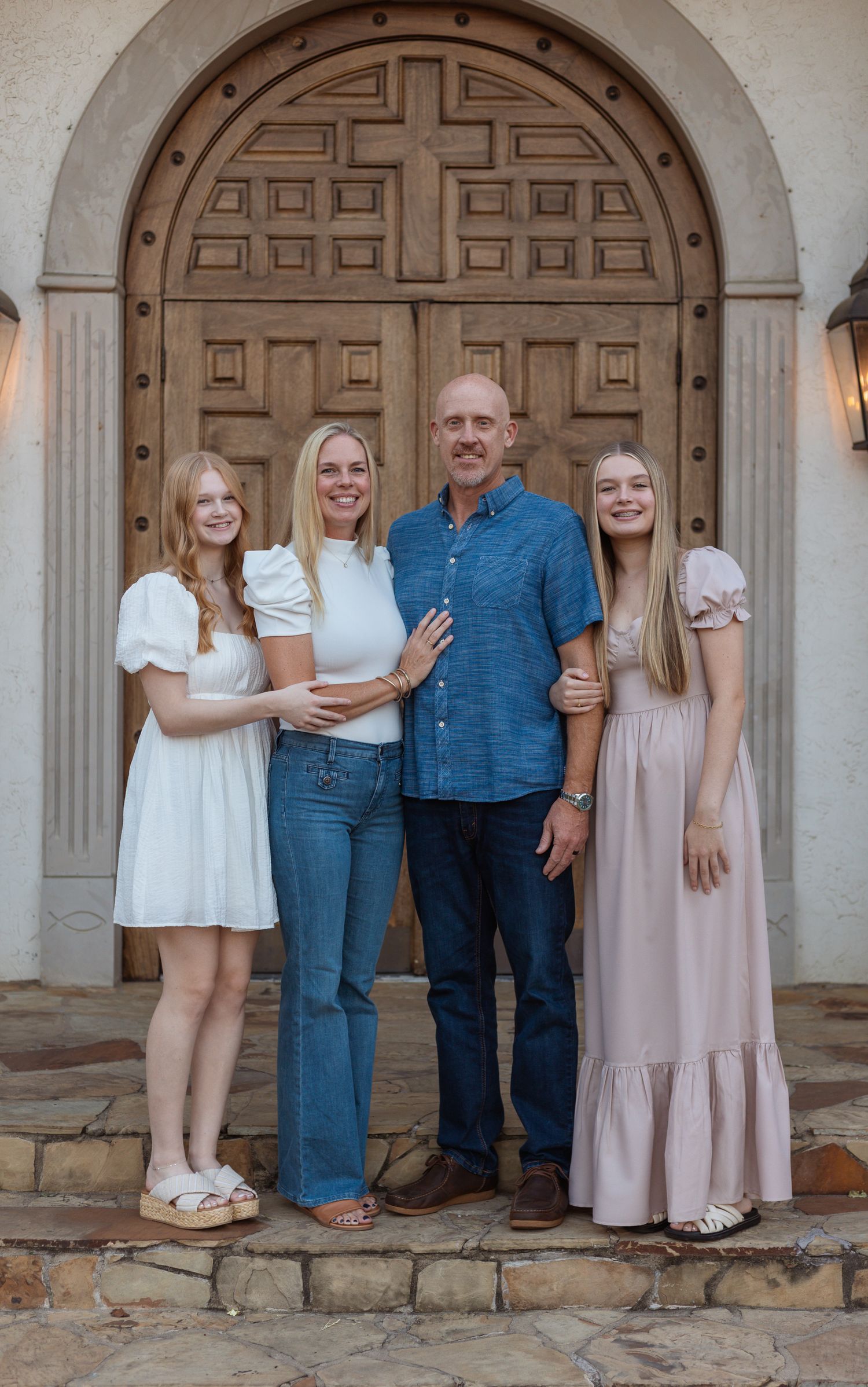 A group portrait in front of a decorative wooden church door.