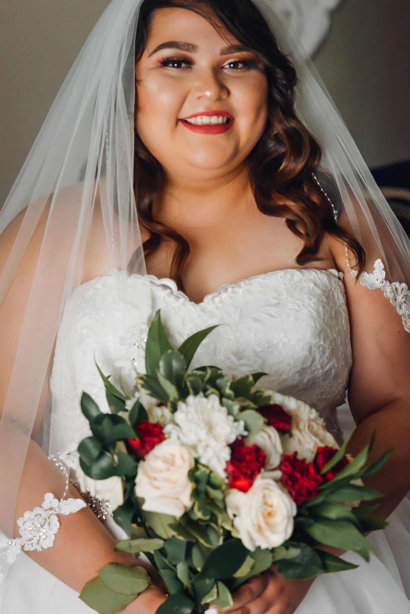Close-up bridal portraits showcasing white lace dress and romantic red and white bouquet.