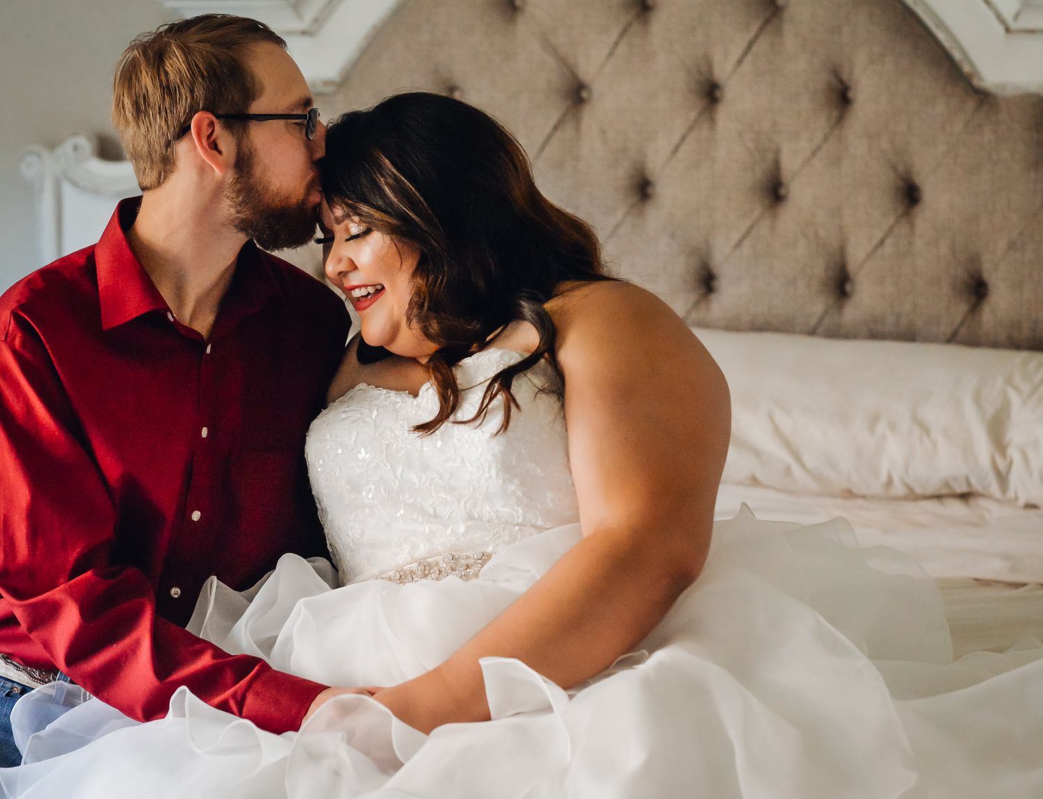 Intimate wedding portraits on tufted beige couch showing romantic moments.