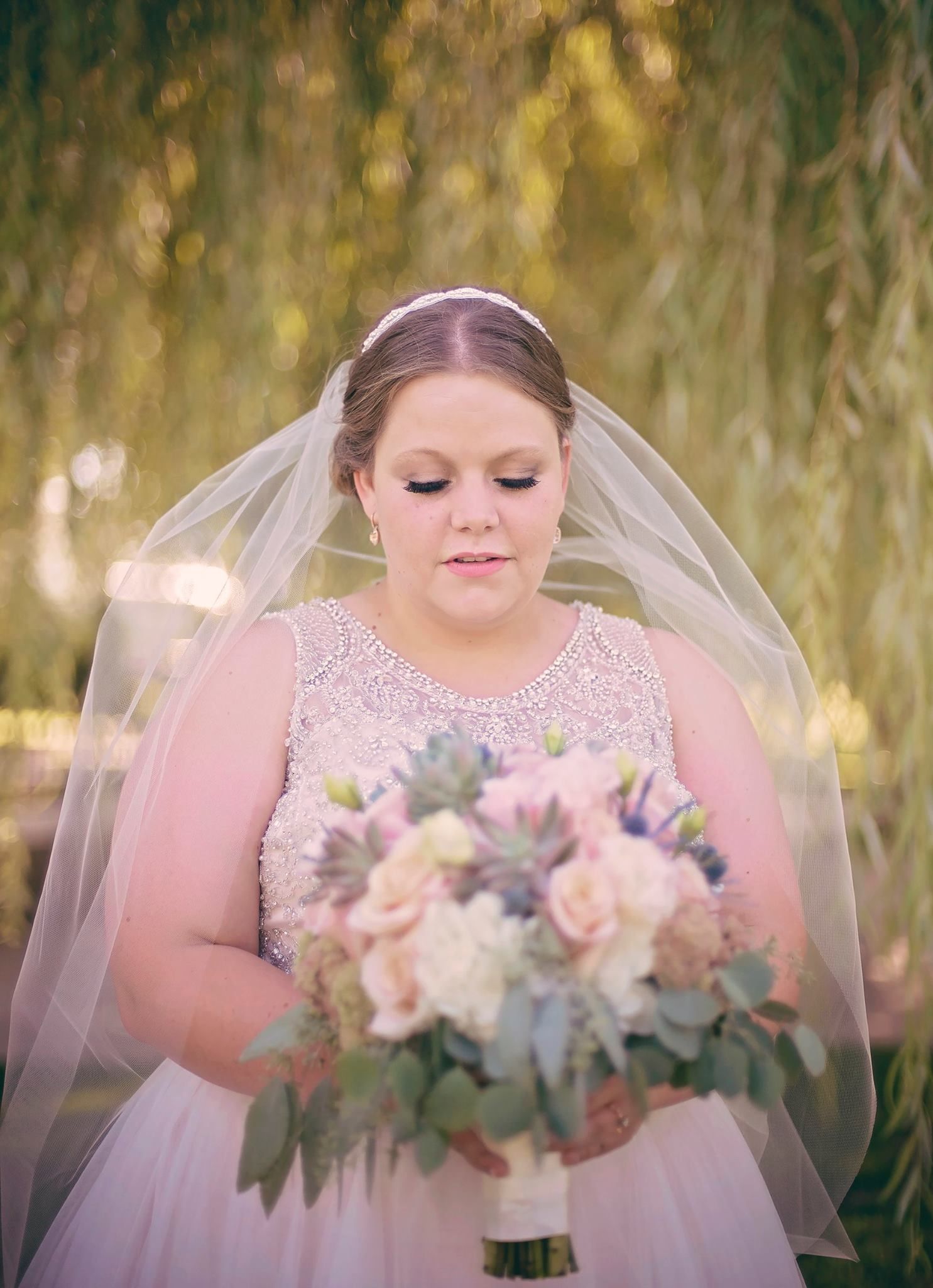 Bridal portrait featuring delicate pink and white bouquet with soft natural lighting.