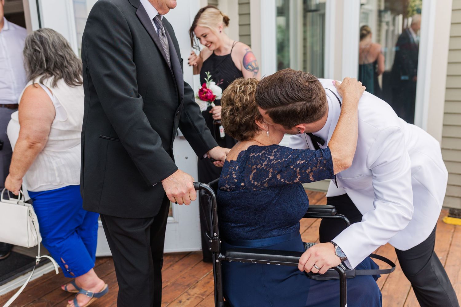 Wedding guests mingling on outdoor patio during elegant summer reception.