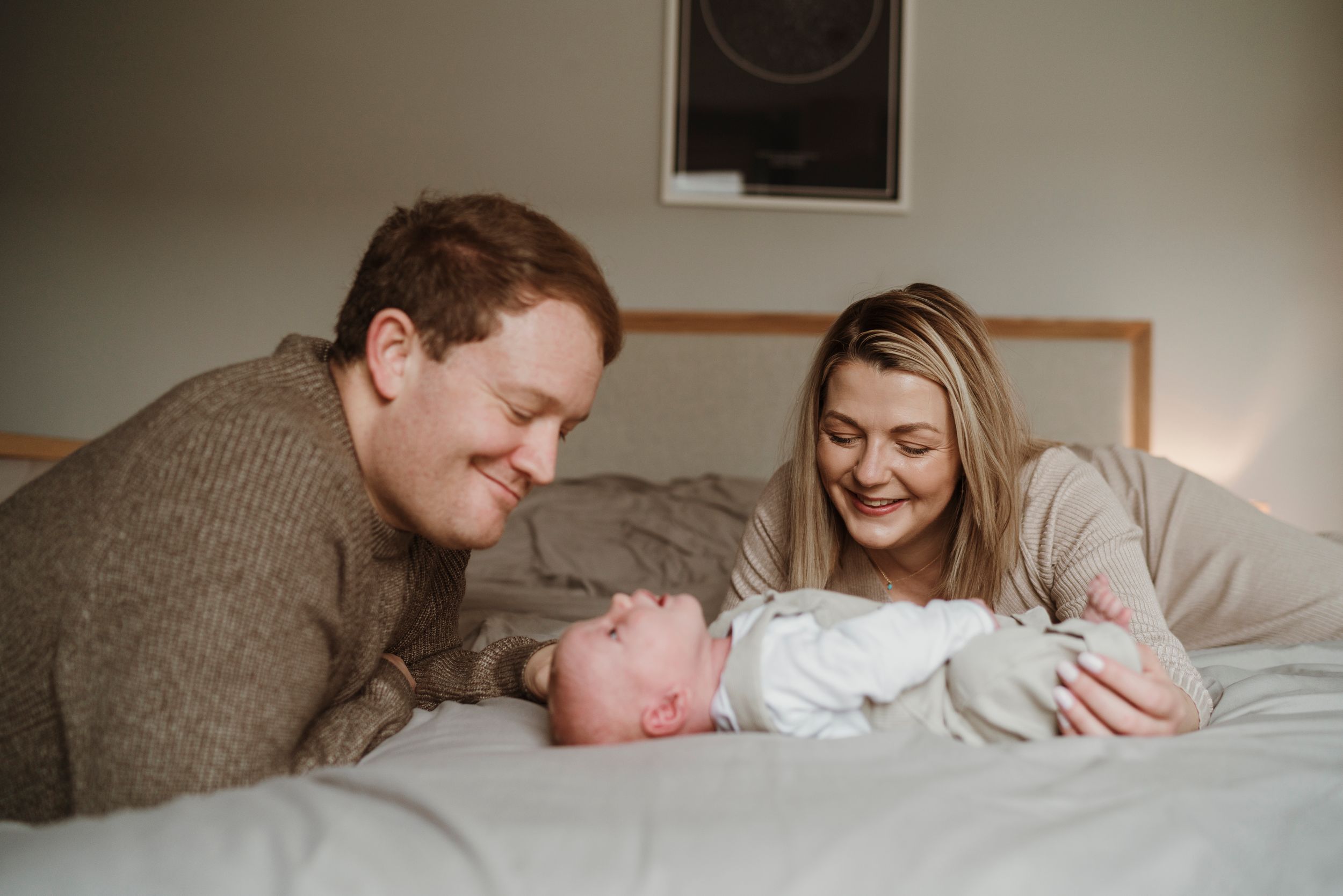 Candid family moment captured on bed during in-home photography session.