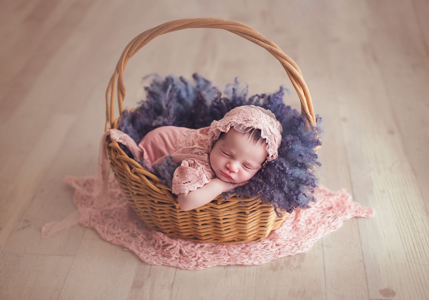 fotografa infantil bebe recien nacida dentro de canasta con ropa en color rosa viejo