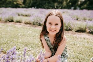 Portrait in a lavender field wearing a floral dress on a sunny day.