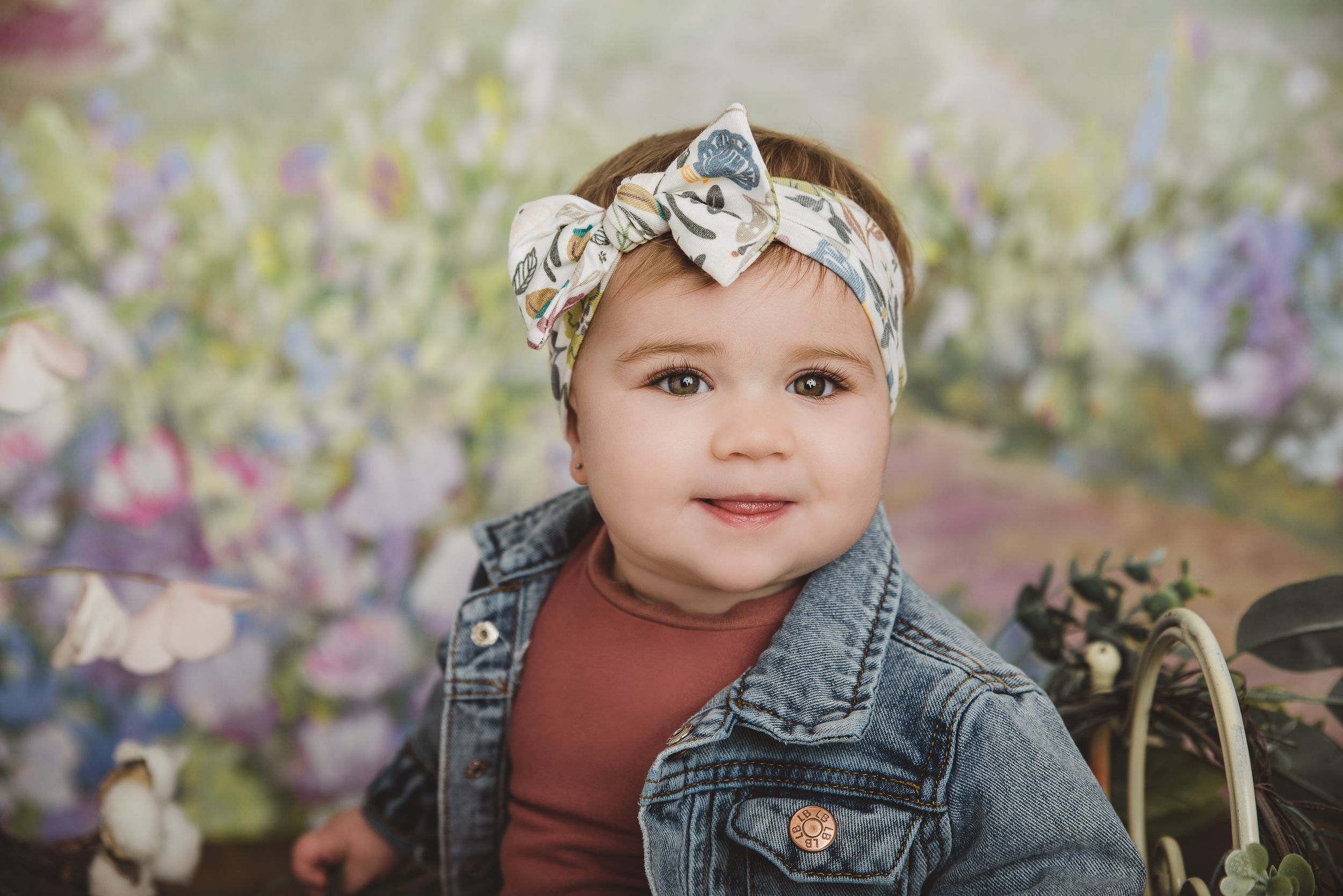 Spring photoshoot setup with floral backdrop and wooden elements in soft pastel colors.