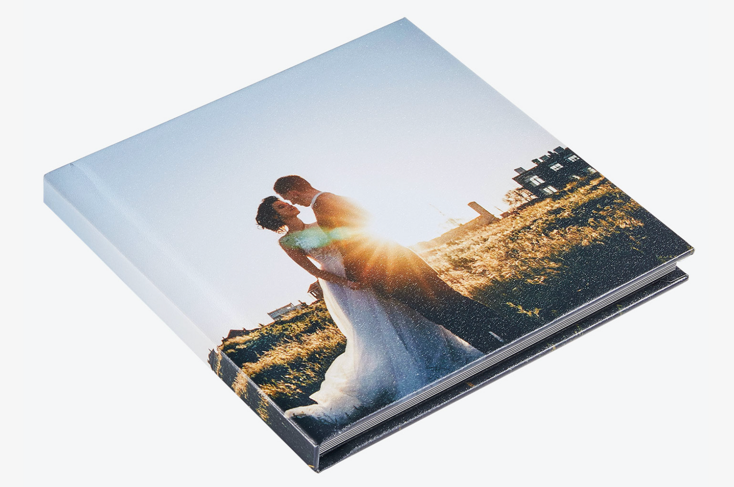 Wedding photo album showing a sunset silhouette of a couple against golden fields.
