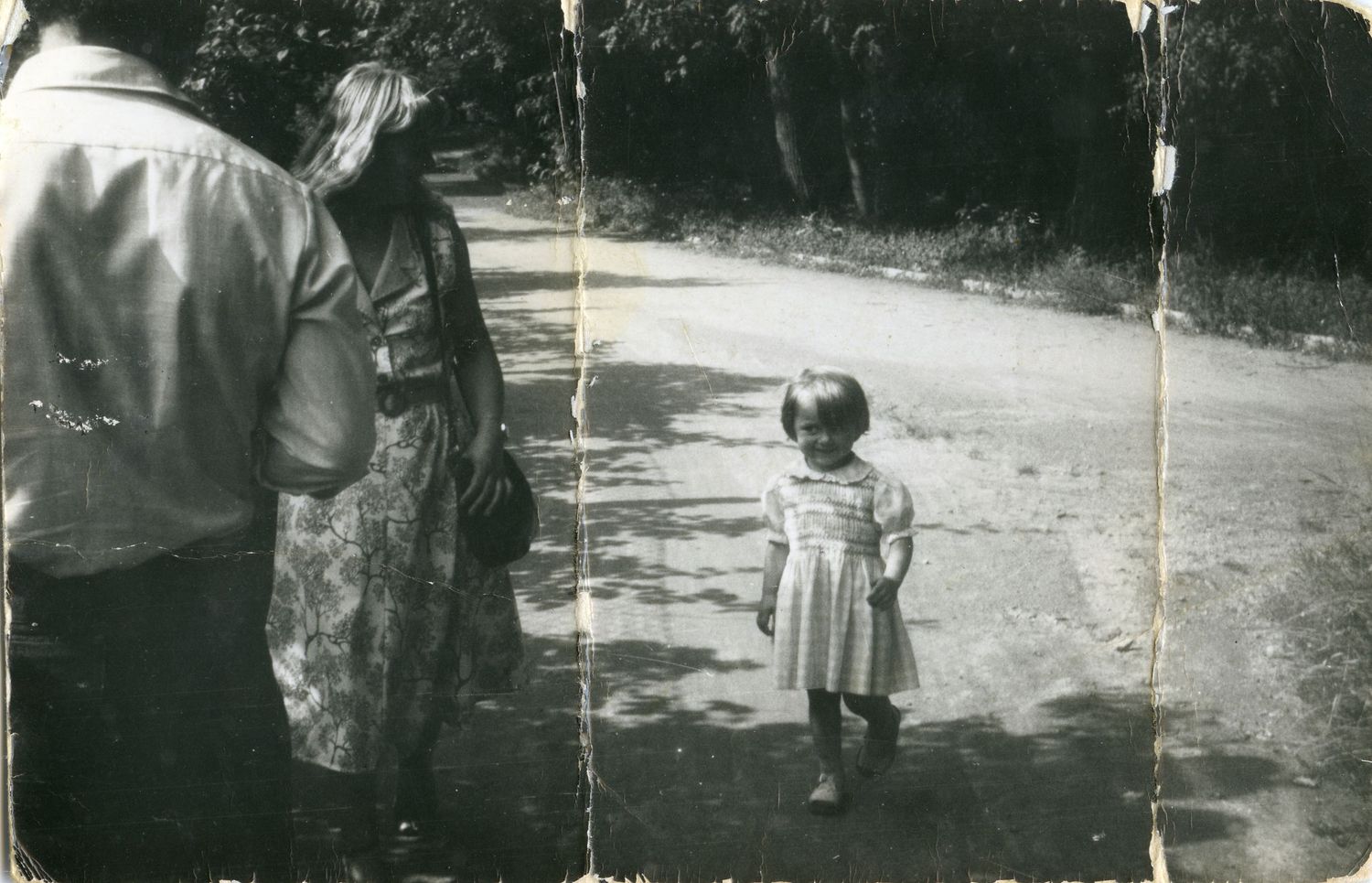 Vintage black and white photo of people walking on a dirt path.
