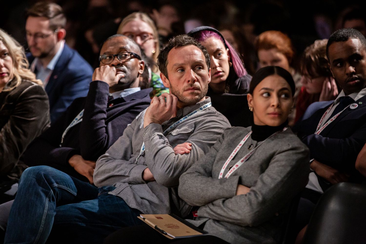 Audience members listening attentively during a conference session.