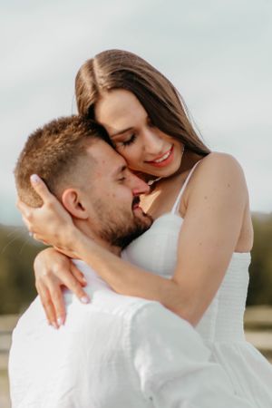 Intimate close-up of couple sharing loving embrace outdoors.