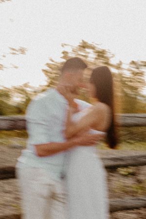 Dreamy soft focus shot of couple embracing outdoors at golden hour.