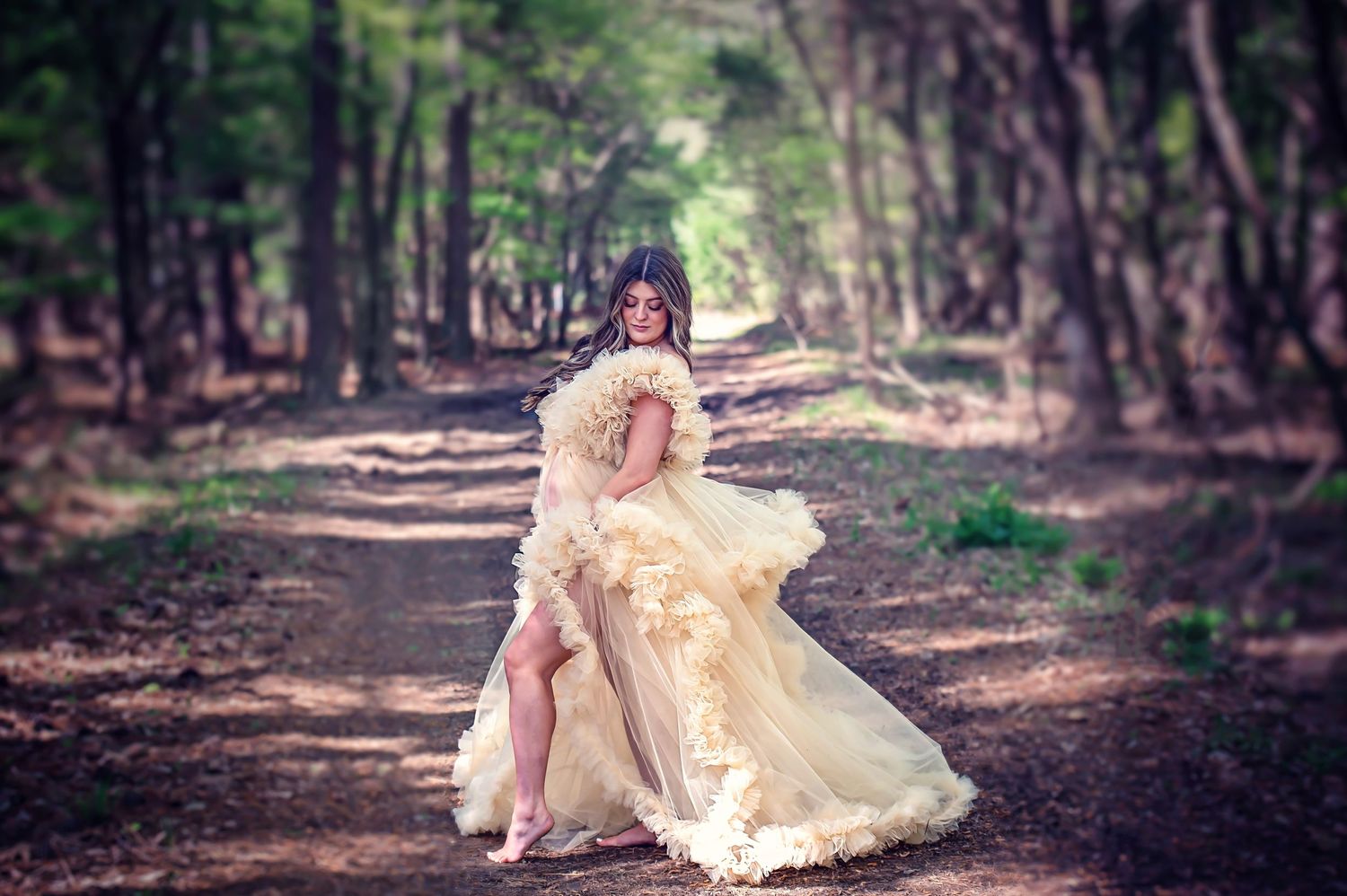 A dreamy forest photography session featuring flowing dress movement along a tree-lined path.
