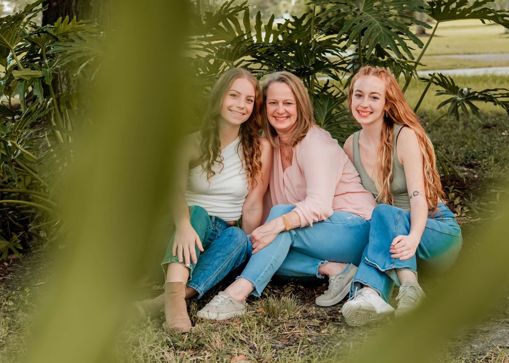 a family of three sitting at Arsenal Park in Baton Rouge