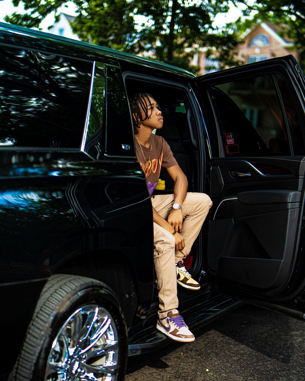 man sitting on edge of black SUV — street style fashion capture by Timoy B Photography.