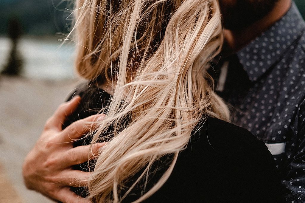 Intimate close-up of blonde hair flowing in breeze with gentle embrace.