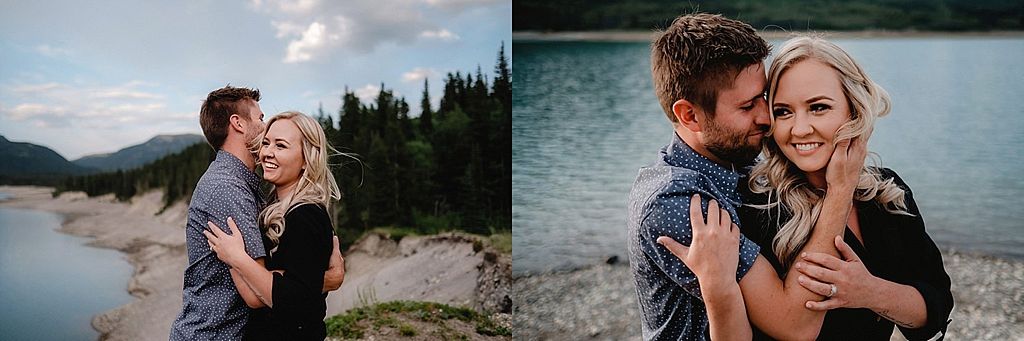 A couple embraces against a mountain lake backdrop during golden hour photography session.