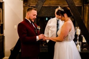 Newlyweds share romantic moments in an elegant indoor venue with warm lighting.