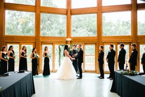 Wedding ceremony with bridal party lined up in black attire.