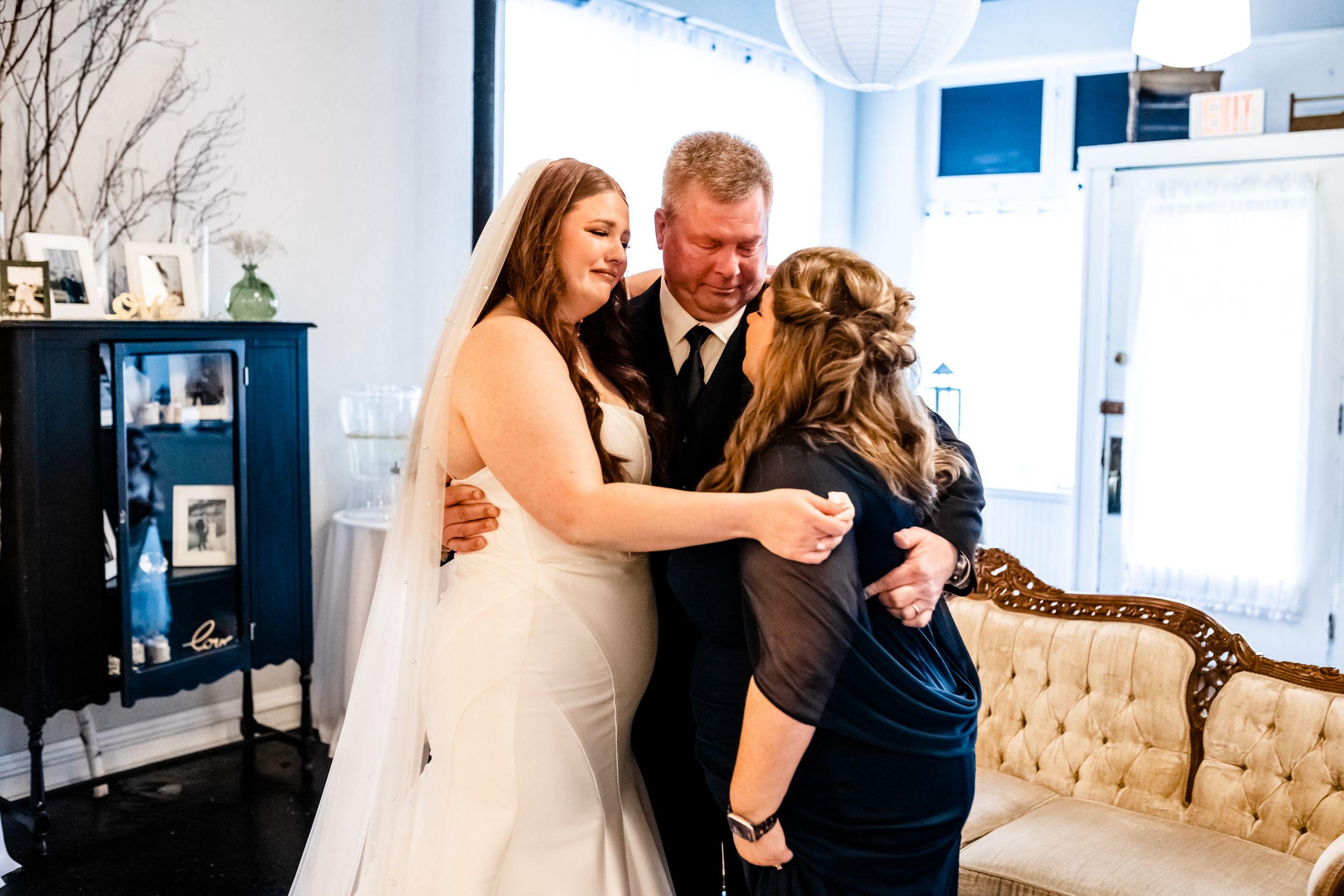 Wedding party gathering in an elegant indoor setting with vintage furniture and natural light.
