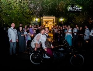 Night time wedding celebration with guests dancing under outdoor lights.