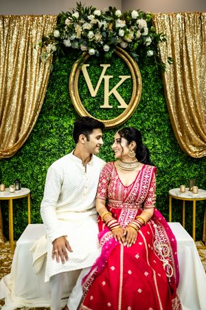 Elegant wedding reception with gold sequin backdrop and floral decorations.