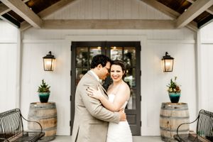 Elegant white farmhouse wedding venue with lanterns and classic architectural details.
