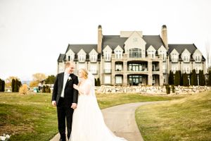 Wedding portraits taken outside a grand estate with classic stone architecture.