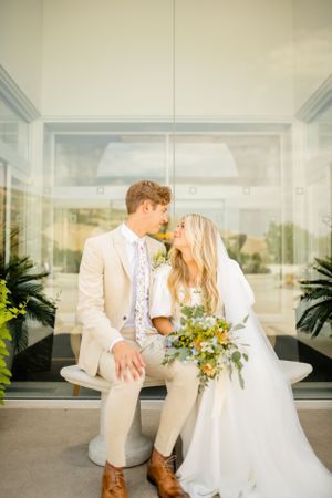 Romantic wedding portraits captured under covered walkway with indoor plants.