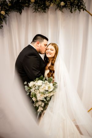 Romantic wedding photo series showing tender moments between a couple against a white backdrop with floral bouquet.