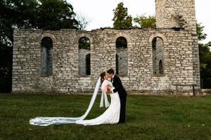 Stone church ruins provide dramatic backdrop for wedding portraits.