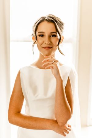 Candid bridal portraits with natural window lighting showing joyful expressions.
