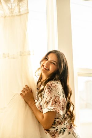 A joyful moment captured by a window with soft natural lighting and floral decor.