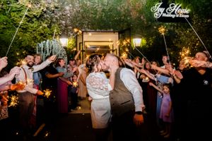 Wedding guests dance and celebrate during outdoor evening reception.