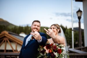 Wedding couple sharing candid moments outdoors with mountain scenery.