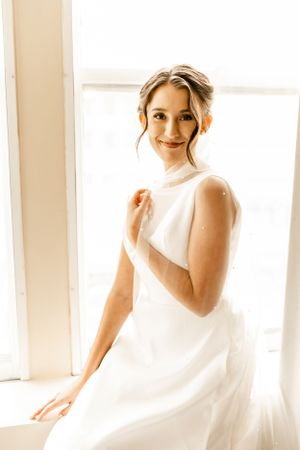 Close-up bridal portraits in soft natural light showing elegant white wedding dress details.